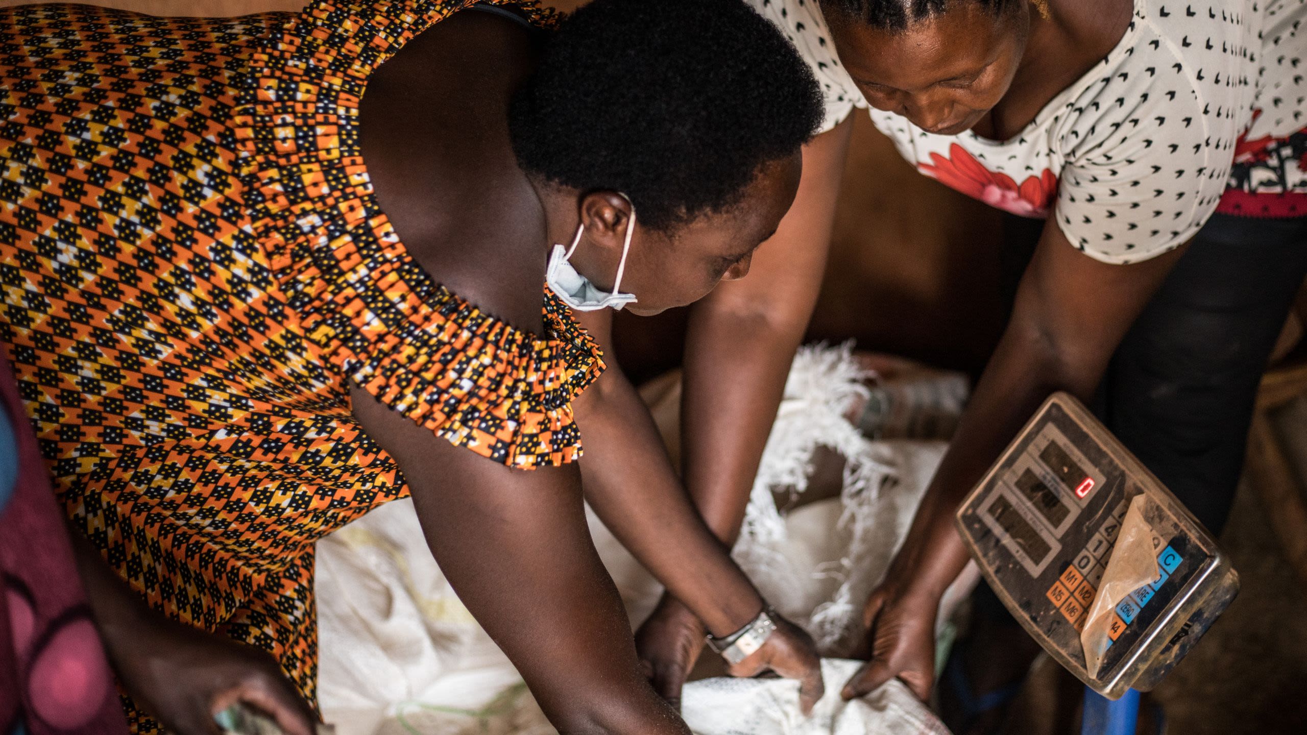 Members of the Urumuri women's group weigh bags of feed for their collective feed business.